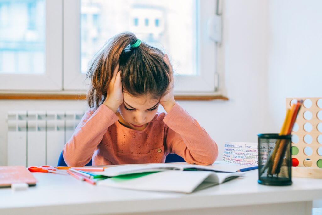 criança com dificuldade de aprendizagem lendo na escola